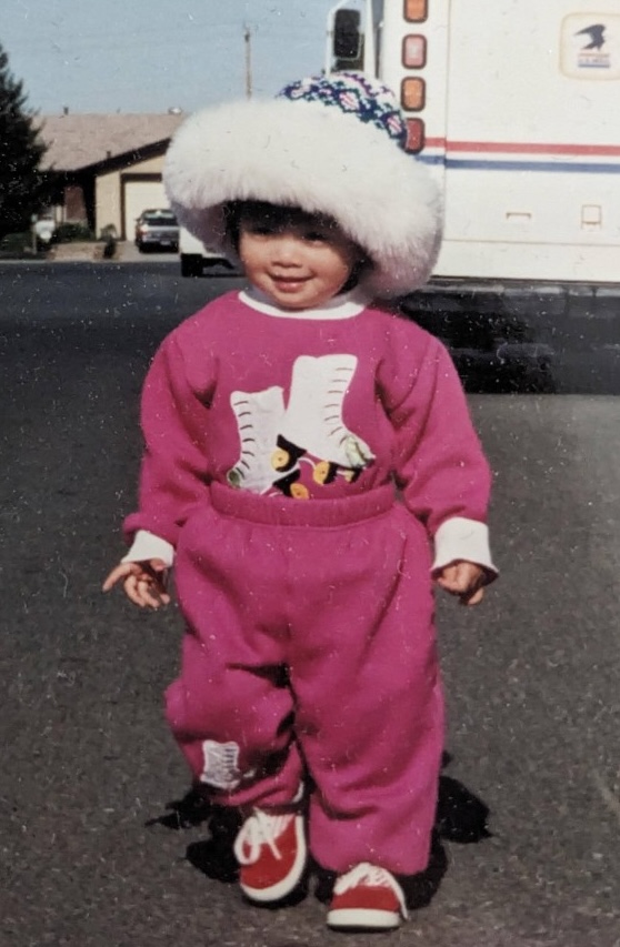 Trang as a child in a pink snowsuit